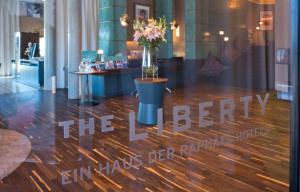 a store window with a vase of flowers on a wooden floor at THE LIBERTY Hotel Bremerhaven BW Signature Collection in Bremerhaven