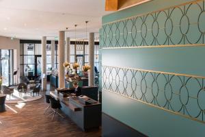 a lobby with a woman sitting at a desk at THE LIBERTY Hotel Bremerhaven BW Signature Collection in Bremerhaven +90 photos