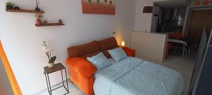 a bedroom with a bed with an orange blanket at Apartamento Elegance Benidorm in Villajoyosa +43 photos