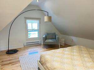 a bedroom with a bed and a chair and a window at Lovely 1- bedroom Unit in Grimsby in Grimsby