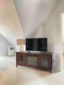 a flat screen tv sitting on top of a wooden entertainment center at Lovely 1- bedroom Unit in Grimsby in Grimsby