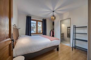 a bedroom with a bed and a window and a mirror at Appartement BOZEN - 100M2- 6 personnes - Bozel - Vallée de Courchevel in Bozel