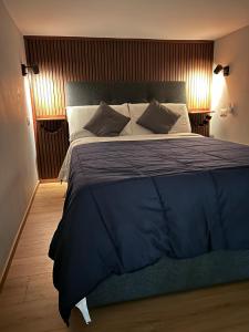 ポッツオーリにあるOdeMar Apartmentの青い毛布が掛けられた大きなベッドのある寝室