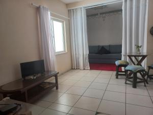 a living room with a television and a couch at Apartamento Céu Azul in Porto Seguro