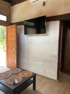 un salon avec une télévision à écran plat sur un mur dans l'établissement Casa dos cuadras de la playa, à Punta Ballena