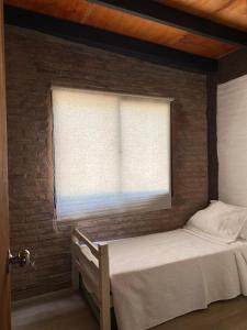 une chambre avec deux lits et une fenêtre dans l'établissement Casa dos cuadras de la playa, à Punta Ballena