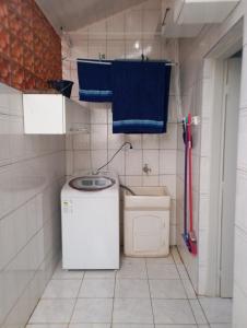 a laundry room with a washing machine and a washer at Apartamento iluminado SLP! in São Luiz do Paraitinga