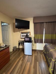 a hotel room with a bedroom with a bed and a television at Snowbird Motel in Bristol
