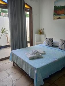 a bedroom with a blue bed with towels on it at Destino Hospeda in Pipa +49 photos