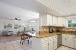 a kitchen with white cabinets and a dining room at Beach Bungalow 2 by Sun Palace Vacations in Fort Myers Beach