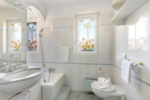 a bathroom with a sink and a tub and a toilet at Villa Anita - Happy Rentals in Caslano +25 photos