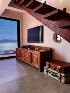 a living room with a flat screen tv on the wall at Nau Loft Refúgio - Capitolio MG in São José da Barra