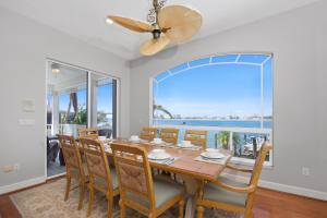 a dining room with a table and chairs and a large window at Dock Holiday by Sun Palace Vacations in Fort Myers Beach