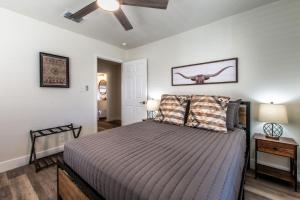 una camera da letto con un letto e un ventilatore a soffitto di Seaside Escape Two Fully Remodeled Homes for Your Group a Corpus Christi
