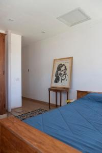 a bedroom with a bed and a painting on the wall at Casa de Playa Los Lobos Chapa in La Estafeta