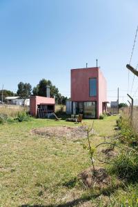 a house sitting on top of a grass field at Casa de Playa Los Lobos Chapa in La Estafeta