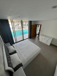 een slaapkamer met een bed en uitzicht op een zwembad bij Eva chalet in Deadsea in Al Kafrayn