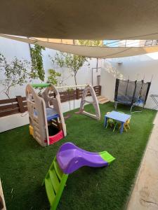 een speeltuin met een glijbaan bij Eva chalet in Deadsea in Al Kafrayn