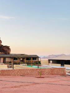 a resort with a pool and mountains in the background at Luxury princes camp in Wadi Rum