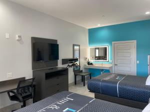 a hotel room with two beds and a flat screen tv at LiV Inn & Suites Houston in Houston