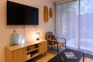 un salon avec une télévision à écran plat au mur dans l'établissement Magnifique appartement au centre-ville de Nice, à Nice