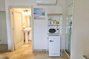 Una pequeña cocina con microondas y nevera. en South of Fifth Family & Pet-Friendly Retreat Across from Best Beach in Miami, en Miami Beach 29 fotos más