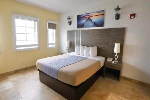 Un dormitorio con una cama grande y dos ventanas. en South of Fifth Family & Pet-Friendly Retreat Across from Best Beach in Miami, en Miami Beach