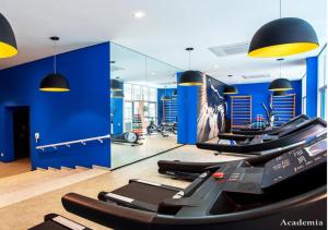 a gym with a row of treadmills and mirrors at APTO Top com Vista pro Mar em Condomínio Completo em Frente à Praia! in Santos