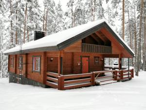 a log cabin with snow on the roof at Villa Naukkari in Syöte