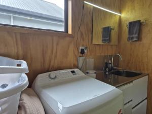 a small bathroom with a sink and a washing machine at Southern Beauty in Luggate +24 photos