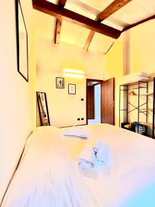 a bedroom with a bed with white sheets at La Casa di Totta in San Maurizio Canavese