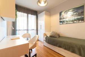 a bedroom with a bed and a desk and a table at Martesana Terrace Flat with garage - Ospedale San Raffaele in Vimodrone