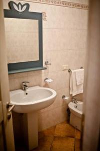 a bathroom with a sink and a mirror and a toilet at Elite Smeralda Room in Porto Rotondo