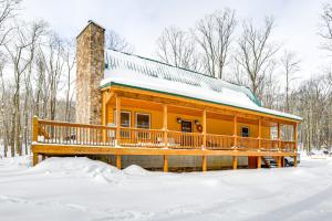 a log cabin in the snow at Hike, Ski and Raft Terra Alta Cabin with Large Deck in Terra Alta