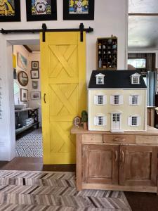 a yellow door in a kitchen with a toy house at The Milking Shed in Kurrajong