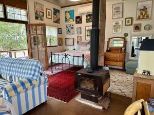 a living room with a wood stove and a bedroom at The Milking Shed in Kurrajong
