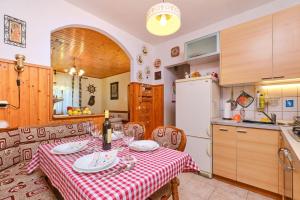 een keuken met een tafel met een rode en witte tafeldoek bij Apartment Giuseppe in Mali Lošinj