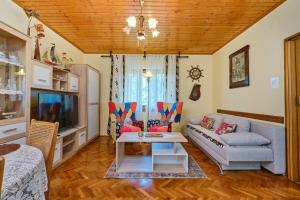 een woonkamer met een bank en een tv bij Apartment Giuseppe in Mali Lošinj