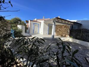 ein weißes Haus mit einer blauen Tür und einigen Pflanzen in der Unterkunft Villa Bambi in Budoni + 58 Fotos