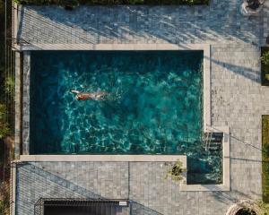 an overhead view of a person swimming in a swimming pool at Villa Green Garden - Infinity Pool, Jacuzzi, Sauna and Panoramic Sea View in Hreljin +69 photos