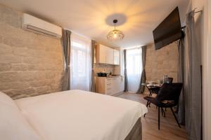 a bedroom with a bed and a table with a chair at Apartment Villa IV in Trogir