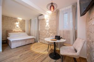 a bedroom with a bed and a table and a chair at Apartment Villa IV in Trogir