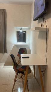 a white table with a chair and a television on a wall at Casa San Isidro in Valladolid