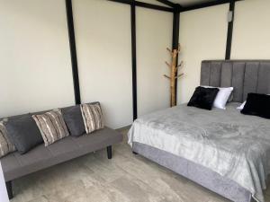 a bedroom with a bed and a couch at Ribs coffee rock glamping in Circasia