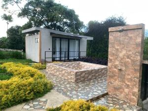 a small house with a stone patio in front of it at Ribs coffee rock glamping in Circasia