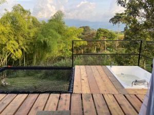 a hot tub on a wooden deck with a view at Ribs coffee rock glamping in Circasia