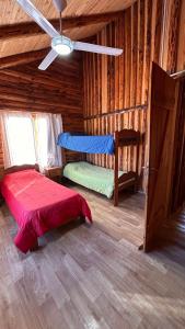 a bedroom with a bed in a log cabin at La Estancia in Trevelín