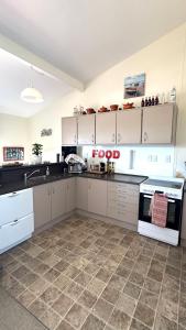 a kitchen with white cabinets and a food sign on the counter at 4 Bedroom Family Beach House in Hauturu
