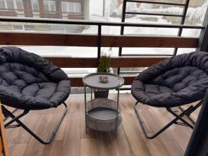 古多里Room 416的阳台上的两把椅子和一张桌子