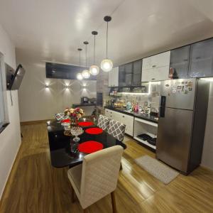 a kitchen with a dining table and a refrigerator at COP 30 suítes em casa confortável in Ananindeua